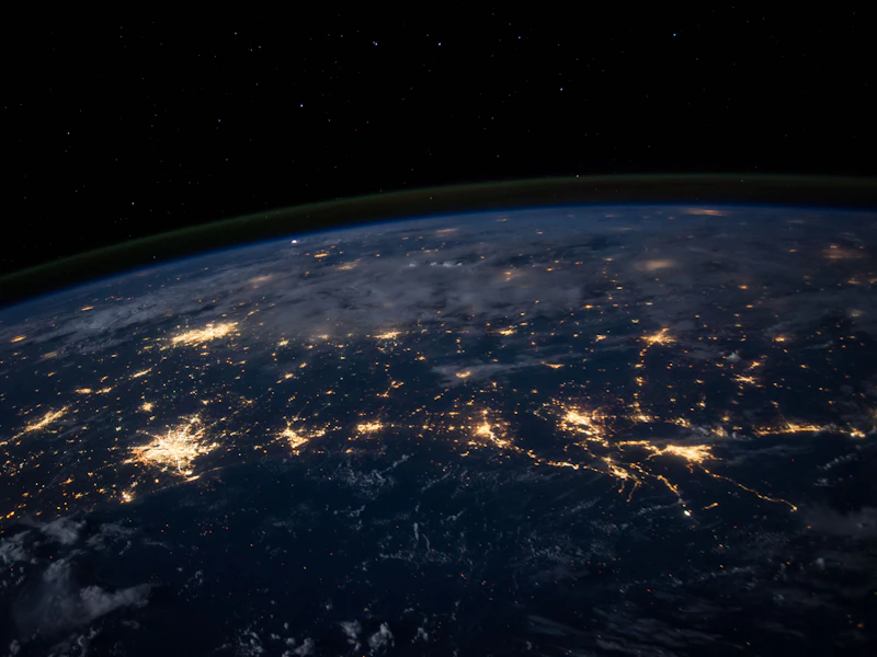 The curve of the Earth at night, city lights scattered across the dark side.